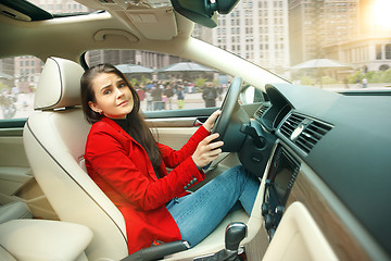 Image showing Driving around city. Young attractive woman driving a car