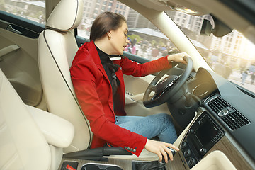 Image showing Driving around city. Young attractive woman driving a car