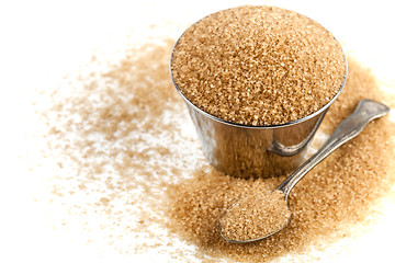 Image showing Brown cane sugar in metal bowl and spoon isolated on white backg