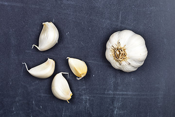 Image showing Fresh raw organic garlic on black board.