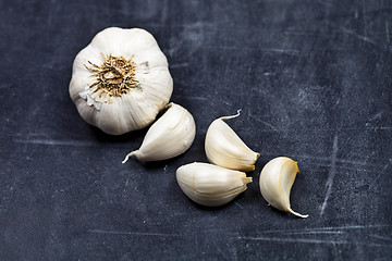 Image showing Fresh raw organic garlic on black board.