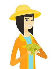 Image showing Young happy asian farmer holding money.