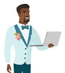 Image showing Young african-american groom using a laptop.