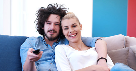 Image showing Young couple on the sofa watching television