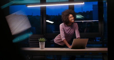 Image showing black businesswoman using a laptop in night startup office