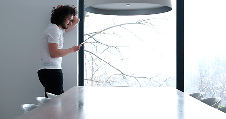 Image showing young man using a tablet at home