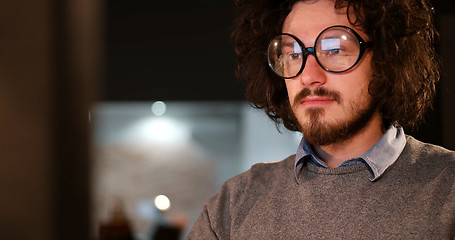 Image showing man working on computer in dark office