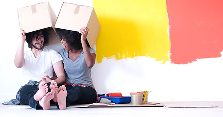 Image showing young multiethnic couple playing with cardboard boxes