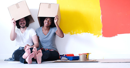 Image showing young multiethnic couple playing with cardboard boxes