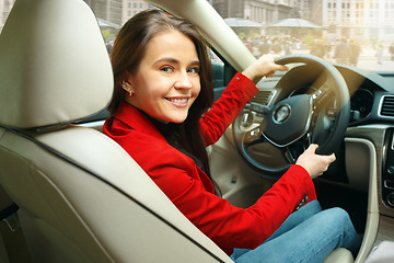 Image showing Driving around city. Young attractive woman driving a car