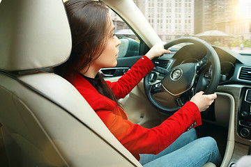 Image showing Driving around city. Young attractive woman driving a car