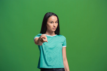 Image showing The overbearing business woman point you and want you, half length closeup portrait on green background.