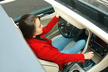 Image showing Driving around city. Young attractive woman driving a car