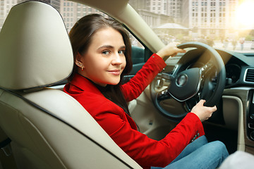 Image showing Driving around city. Young attractive woman driving a car