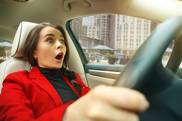 Image showing Driving around city. Young attractive woman driving a car