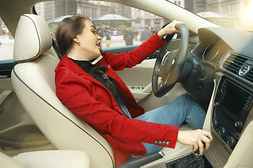 Image showing Driving around city. Young attractive woman driving a car