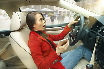 Image showing Driving around city. Young attractive woman driving a car