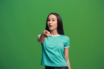 Image showing The happy business woman point you and want you, half length closeup portrait on green background.