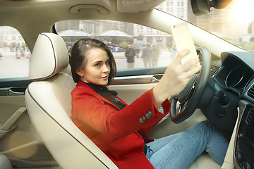 Image showing Driving around city. Young attractive woman driving a car