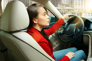 Image showing Driving around city. Young attractive woman driving a car