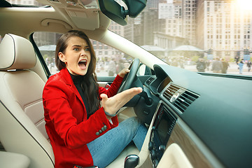 Image showing Driving around city. Young attractive woman driving a car