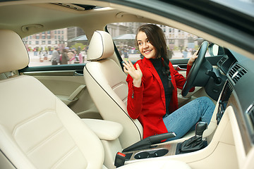 Image showing Driving around city. Young attractive woman driving a car