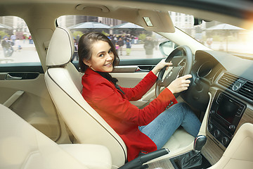 Image showing Driving around city. Young attractive woman driving a car