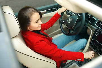 Image showing Driving around city. Young attractive woman driving a car