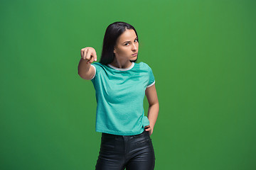 Image showing The overbearing business woman point you and want you, half length closeup portrait on green background.