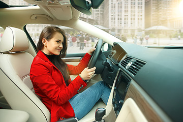 Image showing Driving around city. Young attractive woman driving a car