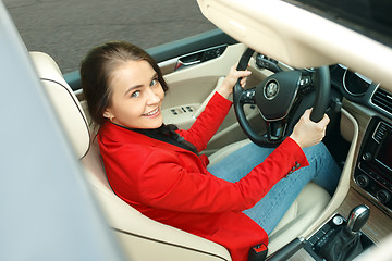 Image showing Driving around city. Young attractive woman driving a car
