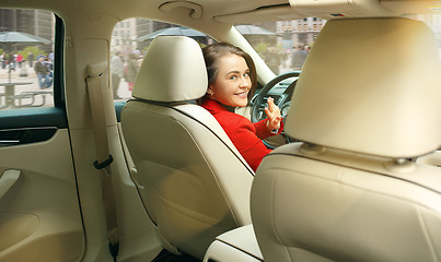 Image showing Driving around city. Young attractive woman driving a car