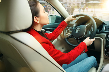 Image showing Driving around city. Young attractive woman driving a car