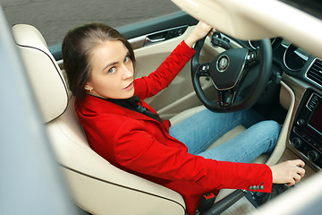 Image showing Driving around city. Young attractive woman driving a car