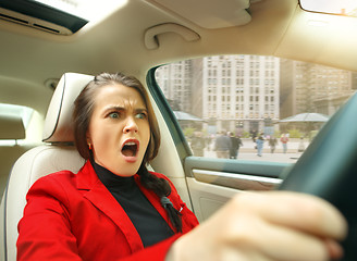 Image showing Driving around city. Young attractive woman driving a car