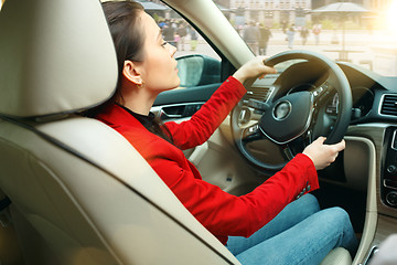 Image showing Driving around city. Young attractive woman driving a car