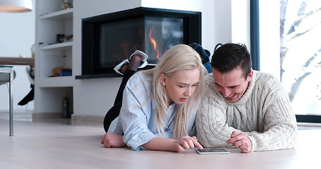 Image showing Young Couple using digital tablet on the floor