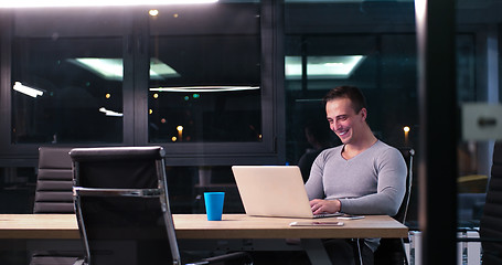 Image showing man working on laptop in dark office