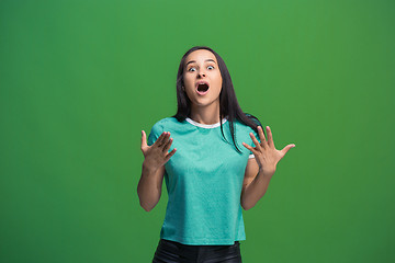 Image showing Beautiful woman looking suprised isolated on green