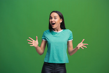 Image showing The happy business woman standing and smiling against green background.