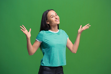 Image showing The happy business woman standing and smiling against green background.