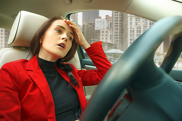 Image showing Driving around city. Young attractive woman driving a car