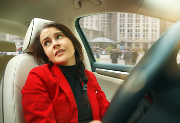 Image showing Driving around city. Young attractive woman driving a car