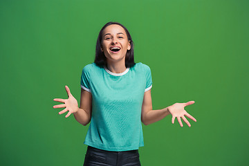 Image showing The happy business woman standing and smiling against green background.