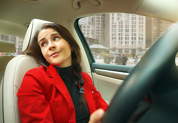 Image showing Driving around city. Young attractive woman driving a car