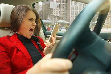 Image showing Driving around city. Young attractive woman driving a car