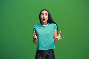 Image showing Beautiful woman looking suprised isolated on green