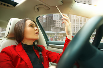 Image showing Driving around city. Young attractive woman driving a car