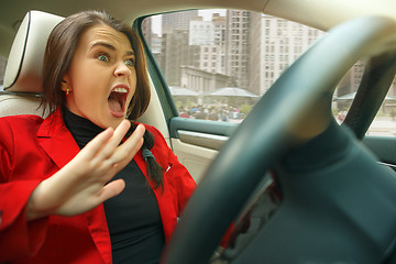 Image showing Driving around city. Young attractive woman driving a car