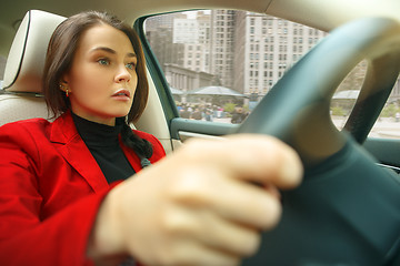 Image showing Driving around city. Young attractive woman driving a car